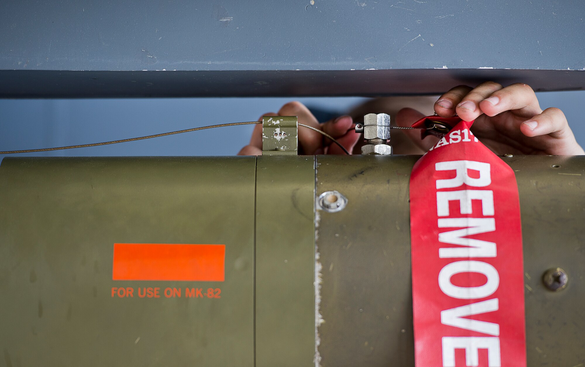 An F-15 Eagle weapons load crew member feeds a small wire through a pin hole while securing an MK-82 bomb to the aircraft during the 96th Aircraft Maintenance Squadron’s first quarter weapons load competition March 19 at Eglin Air Force Base, Fla.  The Red F-15 team battled the Blue F-16 Fighting Falcon crew for quickest and most accurate load of a bomb and missile on their respective aircraft.  (U.S. Air Force photo/Samuel King Jr.)