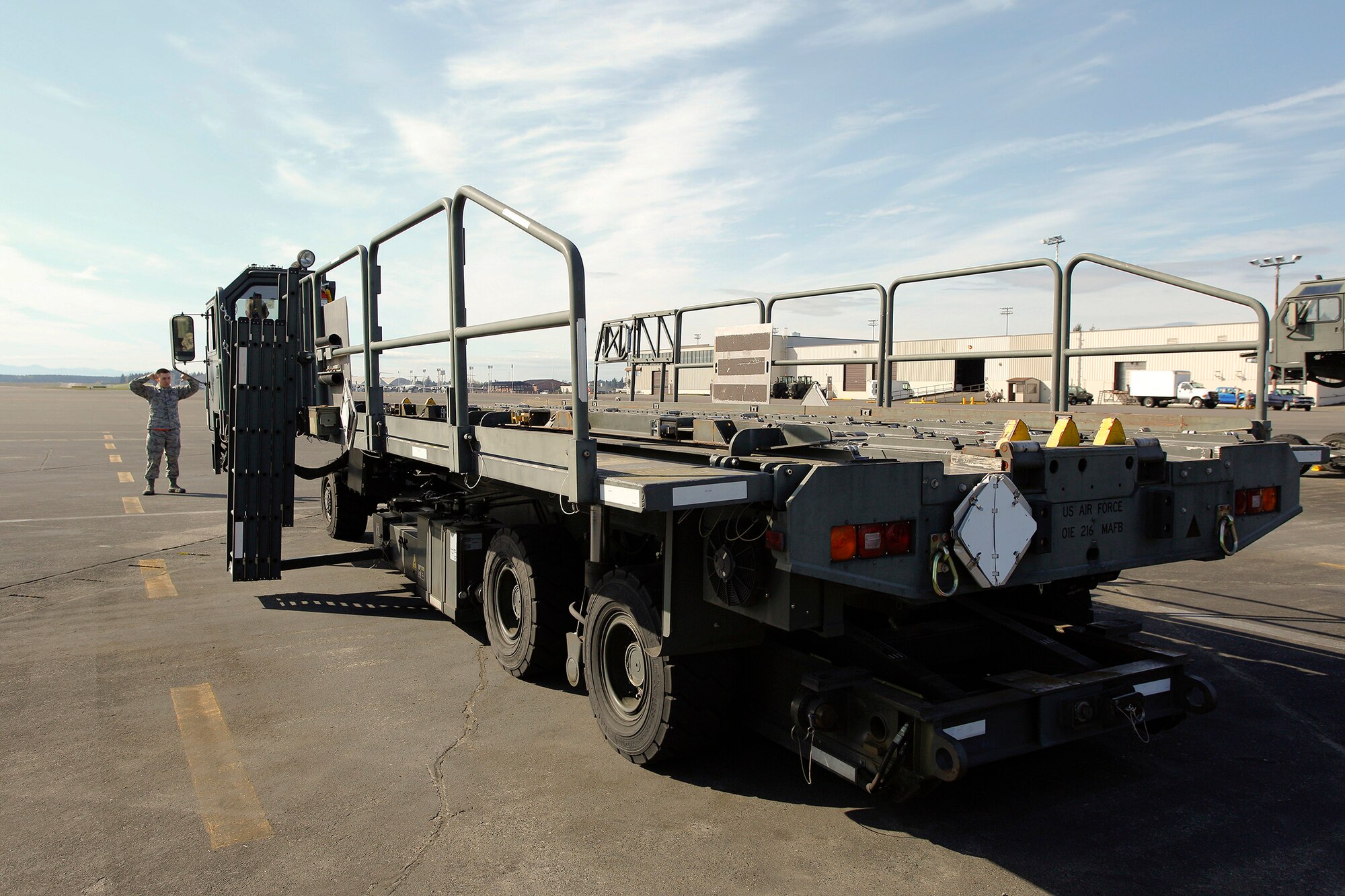 Airman 1st Class Will Akers, 86th Aerial Port Squadron cargo specialist, spots Tech. Sgt. Sarah Ourso, 86th APS load planner, in the Halvorsen Loader, also known as a 25K loader, March 27. Operating and spotting on the Halvorsen is one of the fundamental skill sets new air transportation specialists learn. Both of the Air Force Reserve's aerial port units at McChord Field - 36th and 86th APS - are in the market for new Airmen.(U.S. Air Force Reserve photo by Jake Chappelle)