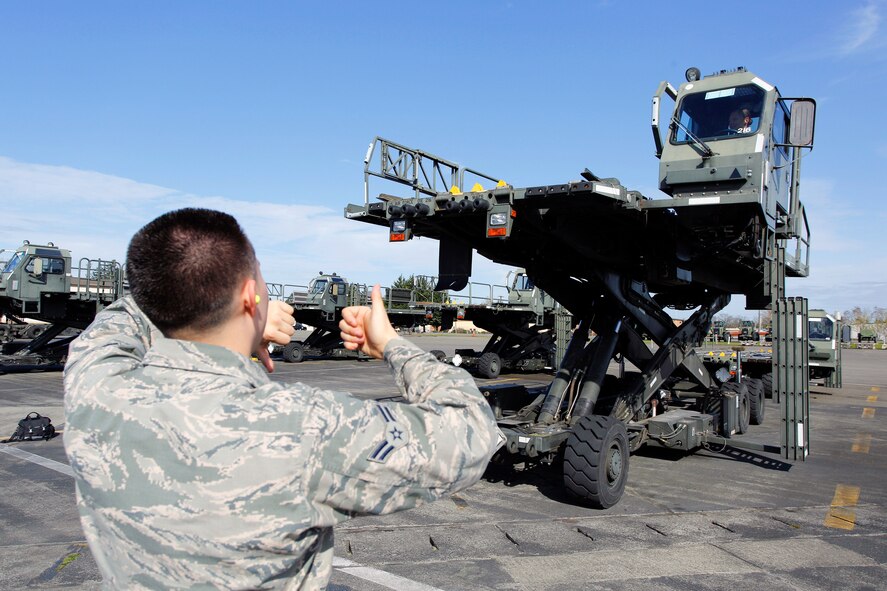 Airman 1st Class Will Akers, 86th Aerial Port Squadron cargo specialist, spots Tech. Sgt. Sarah Ourso, 86th APS load planner, in the Halvorsen Loader, also known as a 25K loader, March 27. Operating and spotting on the Halvorsen is one of the fundamental skill sets new air transportation specialists learn. Both of the Air Force Reserve's aerial port units at McChord Field - 36th and 86th APS - are in the market for new Airmen.(U.S. Air Force Reserve photo by Jake Chappelle)
