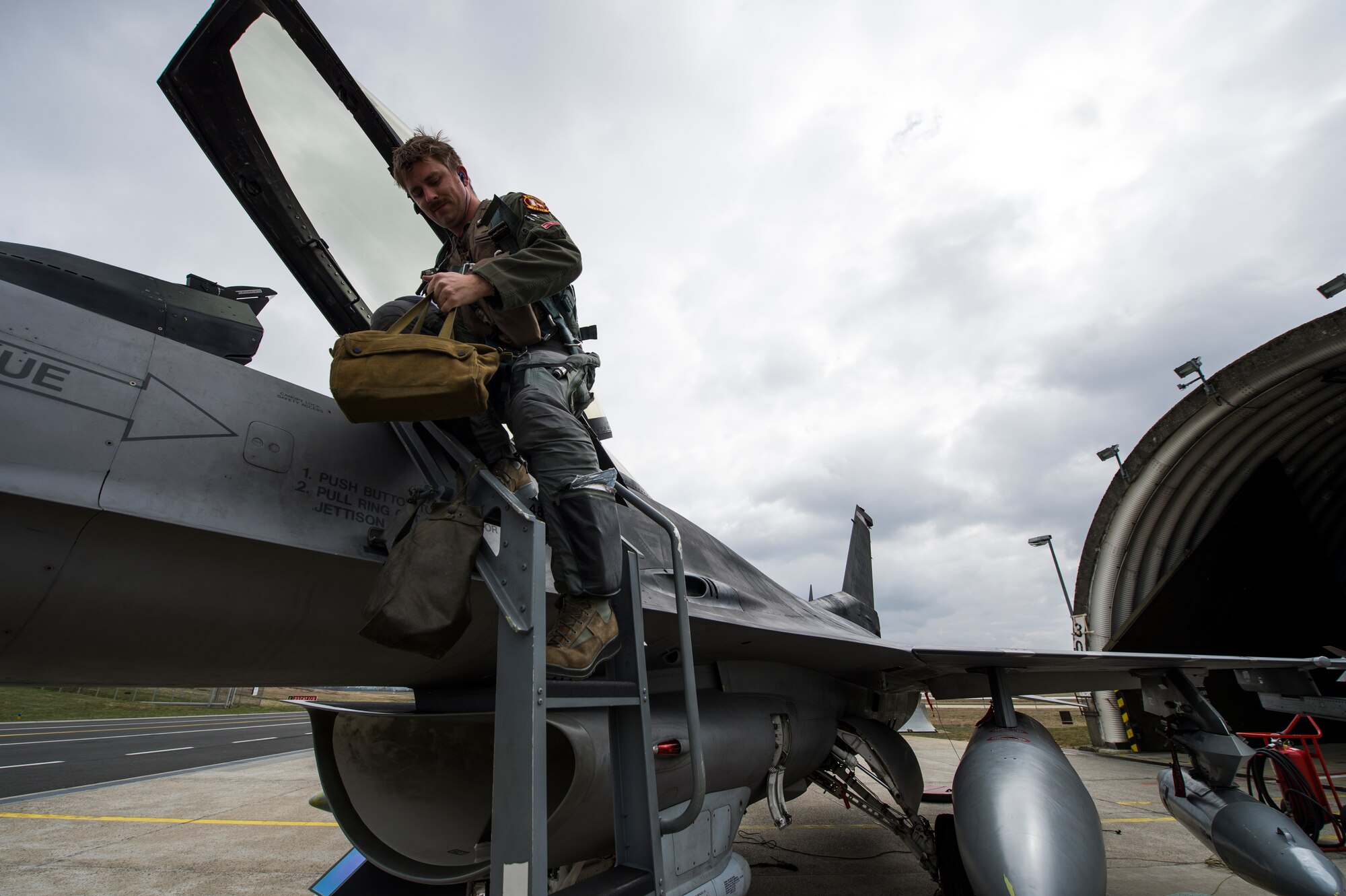 An F-16 Fighting Falcon fighter aircraft pilot assigned to the 480th Fighter Squadron disembarks his aircraft after landing at Spangdahlem Air Base, Germany, March 27, 2015. The pilots that returned were welcomed by their spouses and fellow 480th FS pilots. (U.S. Air Force photo by Staff Sgt. Christopher Ruano) 