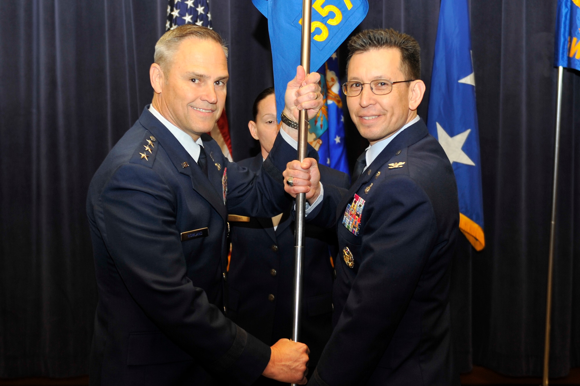 U.S. Air Force Lt. Gen. Chris Nowland, 12th Air Force commander, hands the 557th Weather Wing guidon to U.S. Air Force Col. William Carle, 557th Weather Wing commander, as part of the Air Force Weather Agency’s re-designation to the 557th WW March 27 at the Lt. Gen. Thomas S. Moorman building, Offutt Air Force Base, Nebraska. The Wing, previously a Field Operating Agency, will now fall under Air Combat Command and the 12th Air Force. (U.S. Air Force photo by Jeff Gates/Released)