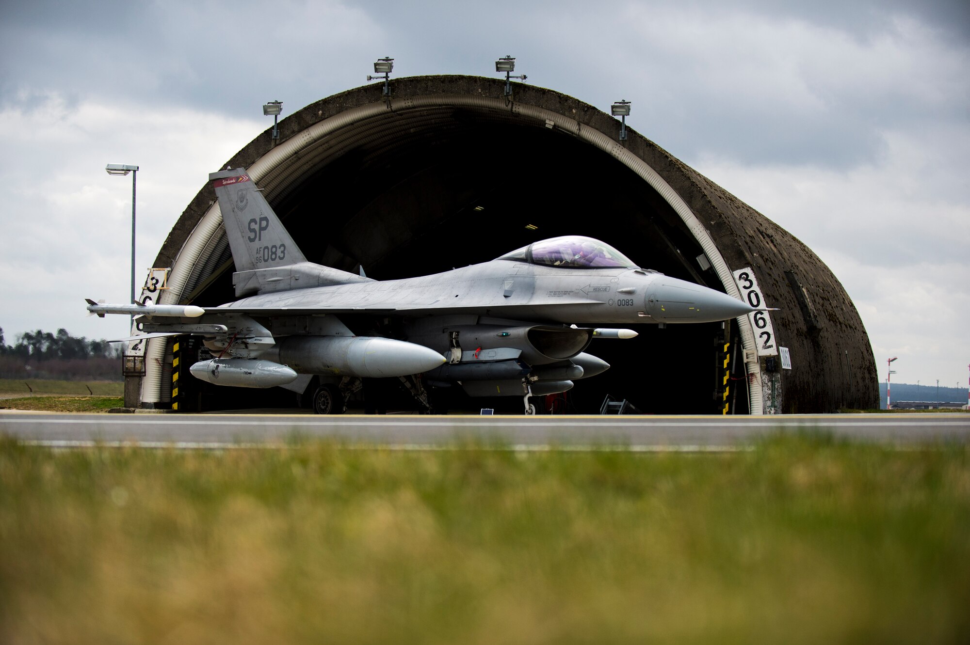 An F-16 Fighter Falcon fighter aircraft assigned to the 480th Fighter Squadron sits outside a hardened aircraft shelter at Spangdahlem Air Base, Germany, after returning from an exercise in Campia Turzii, Romania, March 27, 2015. Approximately 100 Airmen and six F-16s from Spangdahlem participated in the 11-day exercise. (U.S. Air Force photo by Airman 1st Class Luke Kitterman/Released)