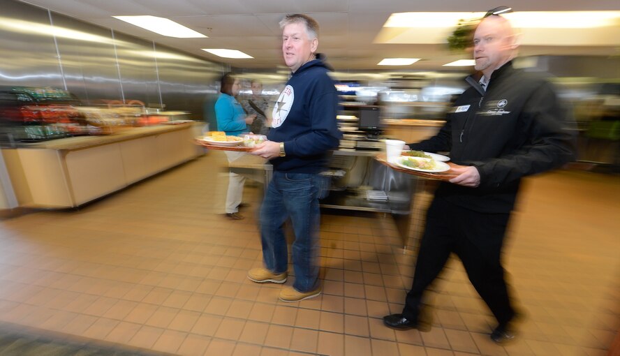Kevin Phillipson, 512th Maintenance Group honorary commander, Air Force Reserve Command, left, and Robert Pancake, 436th Security Forces Squadron honorary commander, right, walk quickly toward the seating area inside the Patten Dining Facility with their lunch during a tour of the 436th Mission Support Group March 18, 2015, on Dover Air Force Base, Del. (U.S. Air Force photo/Greg L. Davis) 