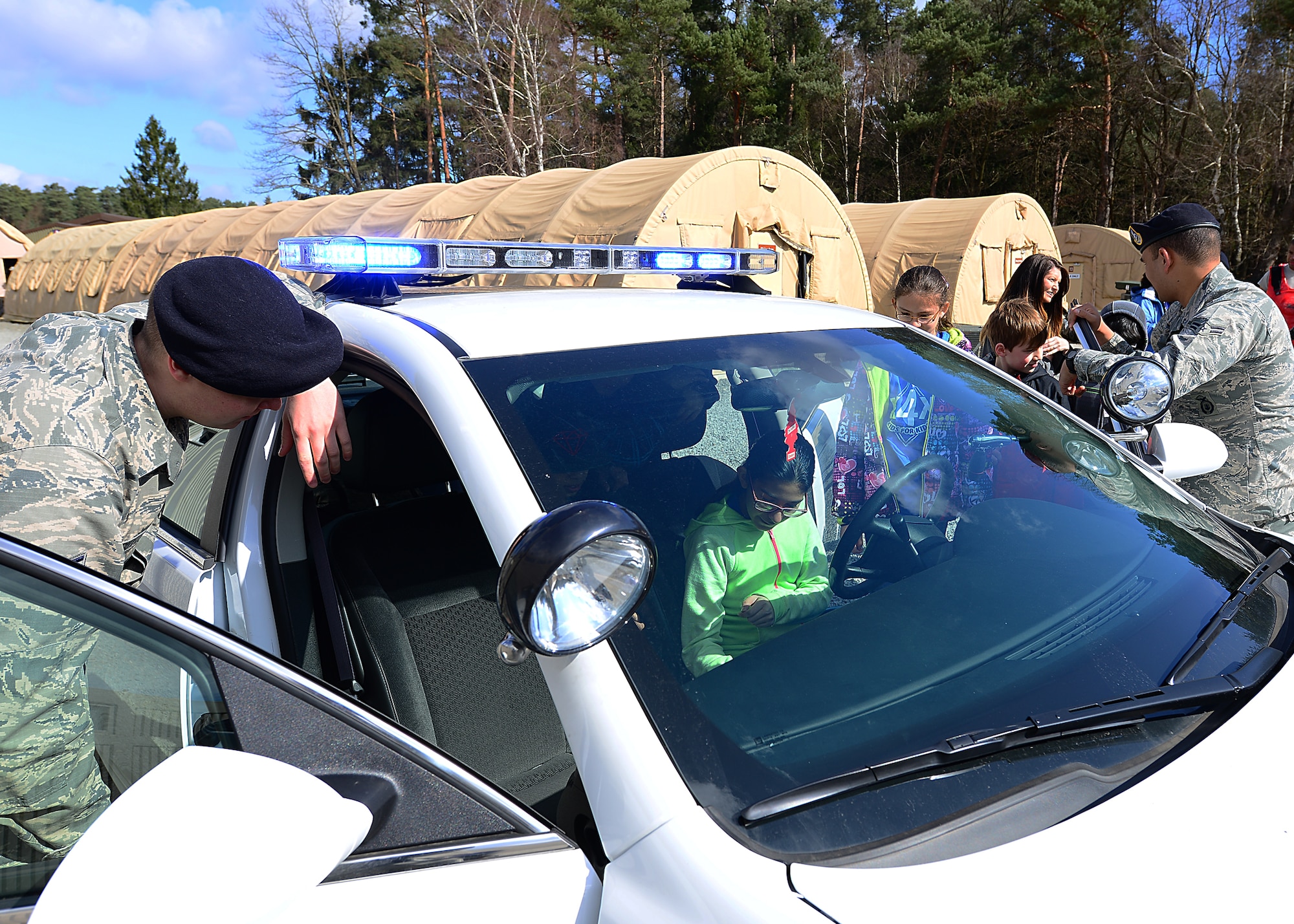 Members from the 86th Security Forces Squadron give Ramstein Intermediate School students a tour of their patrol vehicle during a mock pre-deployment line held on the 435th Air Ground and Operations Wing, 435th Construction and Training Squadron’s silver flag compound, March 27, 2015.  The SFS also had their weapons and tactical gear on display.  (U.S. Air Force photo/Tech. Sgt. Daylena S. Ricks)
