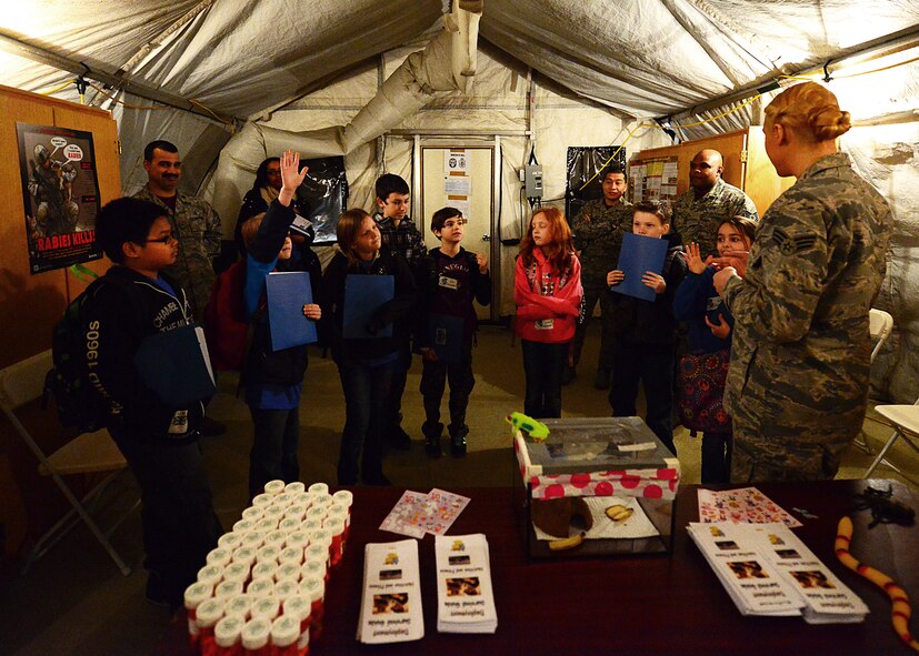 Senior Airman Danielle Marsh, 86th Aerospace Medical Squadron public health technician issues medication [small candies] as well as instructions on taking them during a mock pre-deployment line held on the 435th Air Ground and Operations Wing, 435th Construction and Training Squadron’s silver flag compound, March 27, 2015.  Ramstein units came together and gave RIS students the opportunity to deploy like their Airmen and Soldier parents. (U.S. Air Force photo/Tech. Sgt. Daylena S. Ricks)