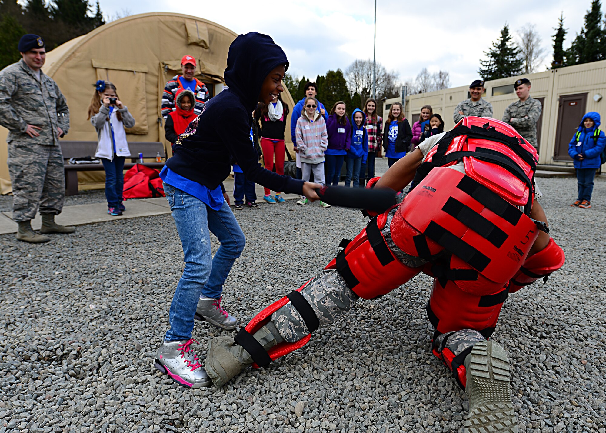 Kinnis Thompson a Ramstein Intermediate School student takes down a posed assailant during the less- than-lethal, force-baton training during a mock pre-deployment line held on the 435th Air Ground and Operations Wing, 435th Construction and Training Squadron’s silver flag compound, March 27, 2015.   Security Forces also had their weapons, tactical gear and patrol vehicle on display. (U.S. Air Force photo/Tech. Sgt. Daylena S. Ricks)