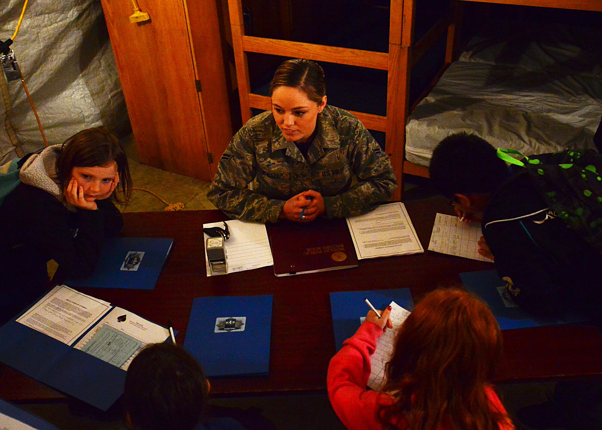 Airman 1st Class April Jewell, 86th Airlift Wing Legal Office general law paralegal explains special power of attorneys to Ramstein Intermediate School students during a mock pre-deployment line held on the 435th Air Ground and Operations Wing, 435th Construction and Training Squadron’s silver flag compound, March 27, 2015.  Each student completed and signed a special power of attorney. (U.S. Air Force photo/Tech. Sgt. Daylena S. Ricks)