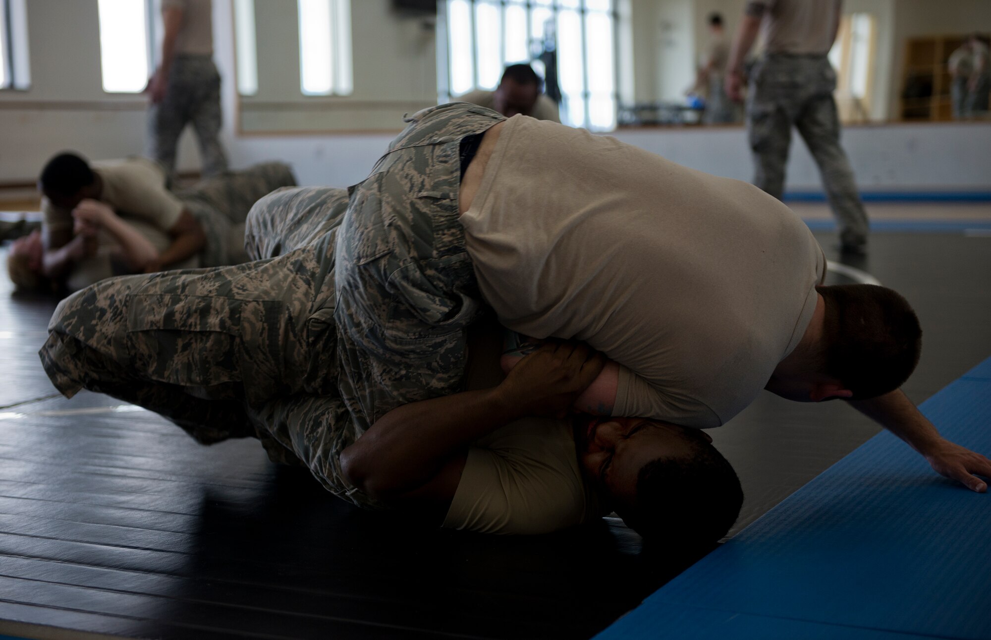 Airman 1st Class Tyler Fulghum, 65th Security Forces Squadron patrolman, flips Airman 1st Class Craig Marks, 65th SFS base defense operations center controller, during part of a combatives class at the Chace Fitness Center on Lajes Field, Azores Portugal, March 24, 2015. This training helps hone members' close-quarters combat techniques and this class will certify them in security forces combatives. (U.S. Air Force photo/Staff Sgt. Zachary Wolf)
