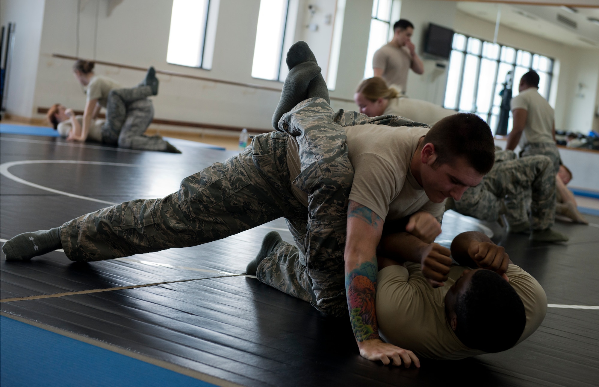 Airman 1st Class Craig Marks, 65th Security Forces Squadron base defense operations center controller, pins Airman 1st Class Tyler Fulghum, 65th SFS patrolman to the ground as part of a combatives class at the Chace Fitness Center on Lajes Field, Azores Portugal, March 24, 2015. This training helps hone members' close-quarters combat techniques and this class will certify them in security forces combatives. (U.S. Air Force photo/Staff Sgt. Zachary Wolf)
