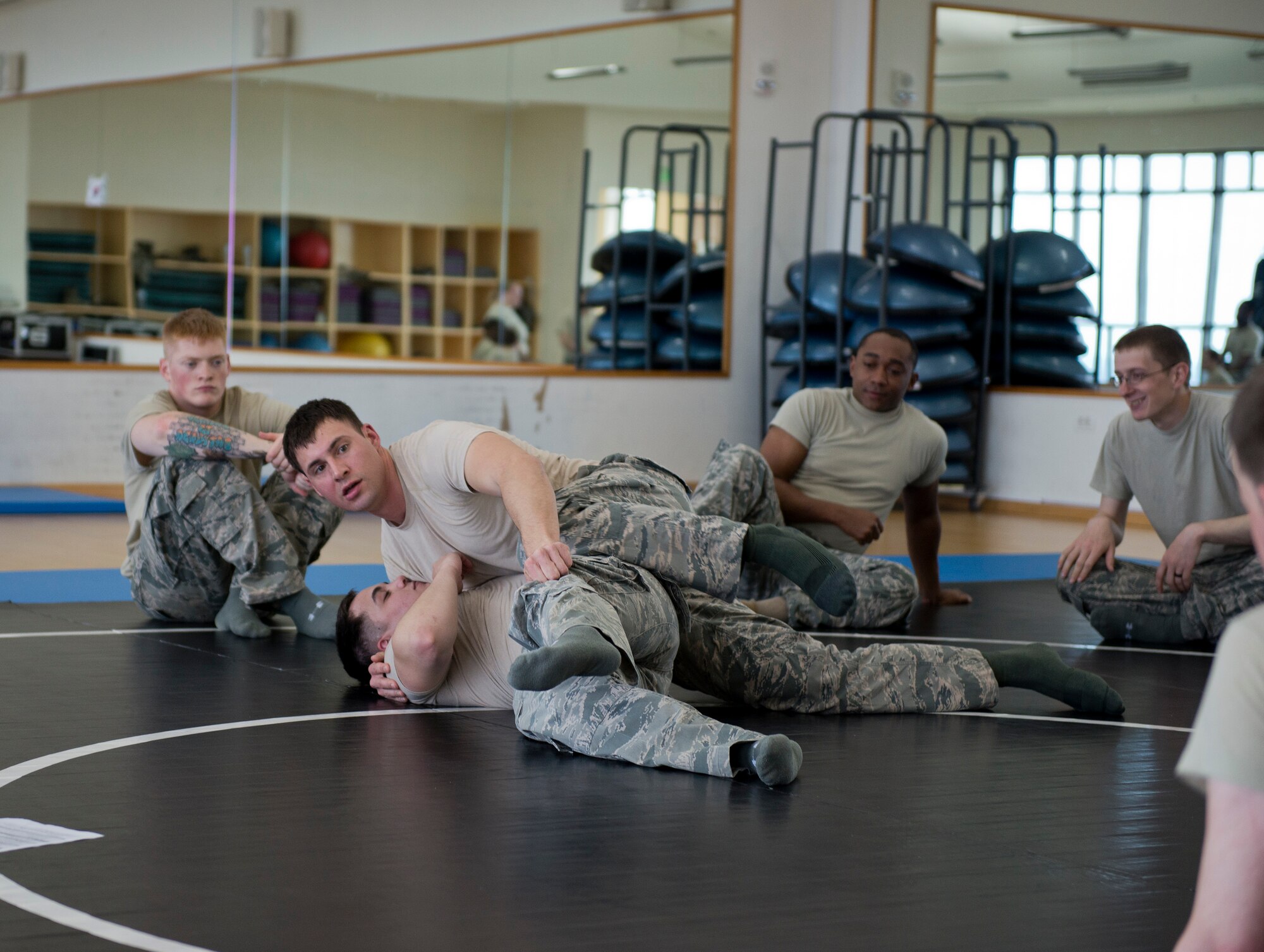 Tech. Sgt. Chance Farmer, 65th Security Forces Squadron noncommissioned officer in charge of training, shows members of the 65th SFS combatives moves at the Chace Fitness Center on Lajes Field, Azores Portugal, March 24, 2015. This training helps hone members' close-quarters combat techniques and this class will certify them in security forces combatives. (U.S. Air Force photo/Staff Sgt. Zachary Wolf)