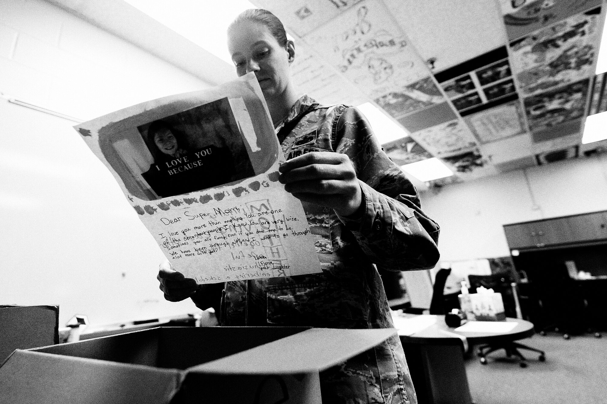 Master Sgt. Amy C. Dotson, 316th Training Squadron instructor, reads a letter from her daughter as she packs up her desk at Goodfellow Air Force Base, Texas, March 13, 2015. Dotson made the decision to end her career prematurely and spend time with family after being diagnosed with multiple sclerosis. (U.S. Air Force photo by Tech. Sgt. Austin Knox)