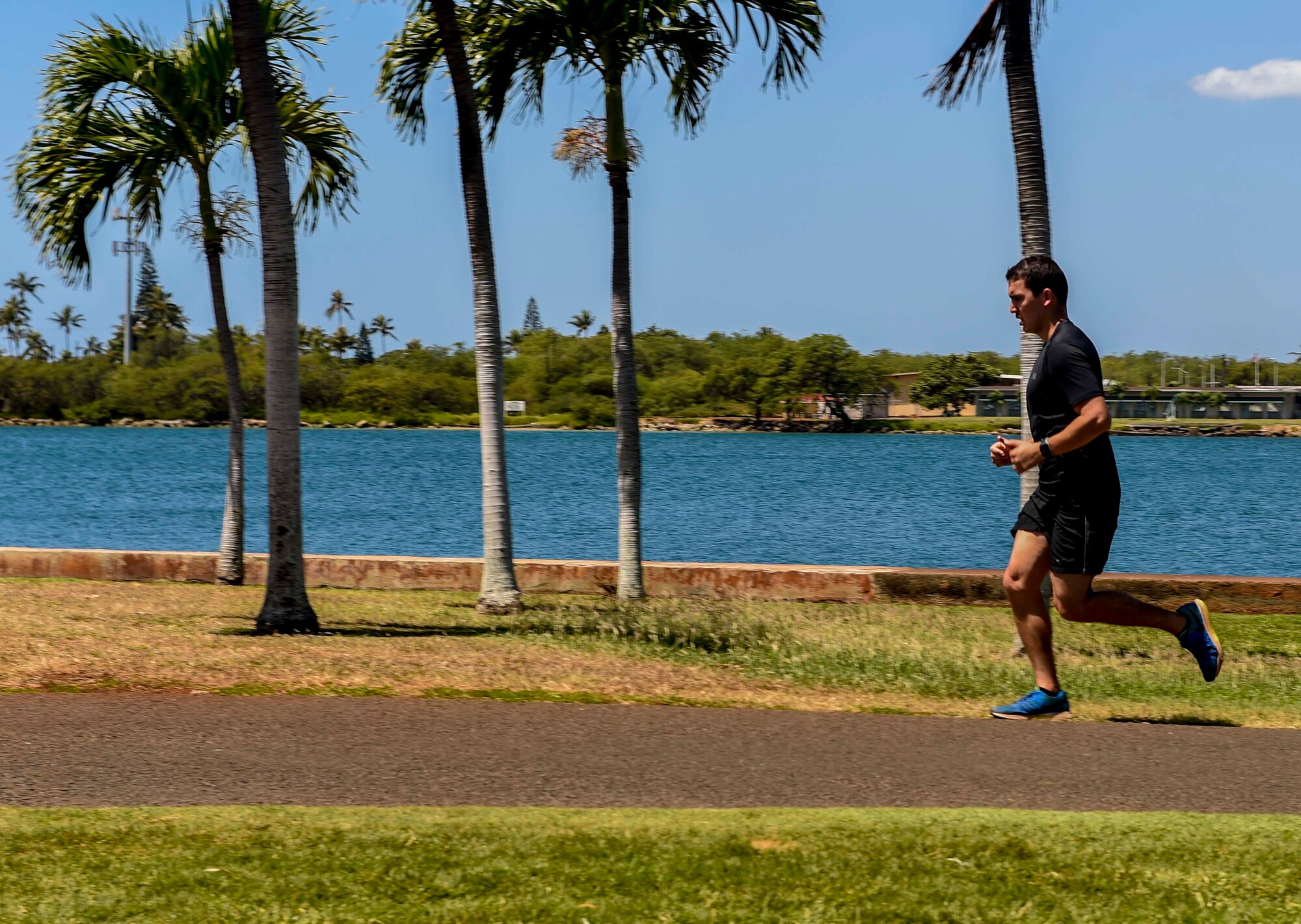 A volunteer runner jogs on the running path overlooking Pearl Harbor during the Tactical Air Control Party (TACP) 4th Annual TACP Remembrance Run on Joint Base Pearl Harbor-Hickam, Hawaii, March 27, 2015. More than 300 Airmen, Soldiers and Sailors from around the island came to pay their respects and support the event hosted by the 25th Air Operations Support Squadron. (U.S. Air Force by photo by Tech. Sgt. Terri Paden)