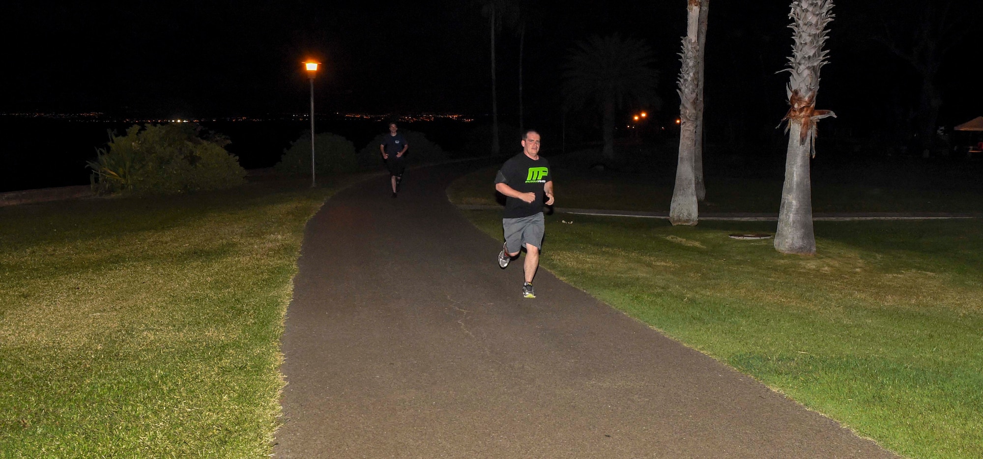 A volunteer runner jogs on the running path overlooking Pearl Harbor during the Tactical Air Control Party (TACP) 4th Annual TACP Remembrance Run on Joint Base Pearl Harbor-Hickam, Hawaii, March 27, 2015. More than 300 Airmen, Soldiers and Sailors from around the island came to pay their respects and support the event hosted by the 25th Air Operations Support Squadron. The 24-hour run began at noon March 26 and ended at 12:59 p.m. March 27.  (U.S. Air Force by photo by Tech. Sgt. Terri Paden)