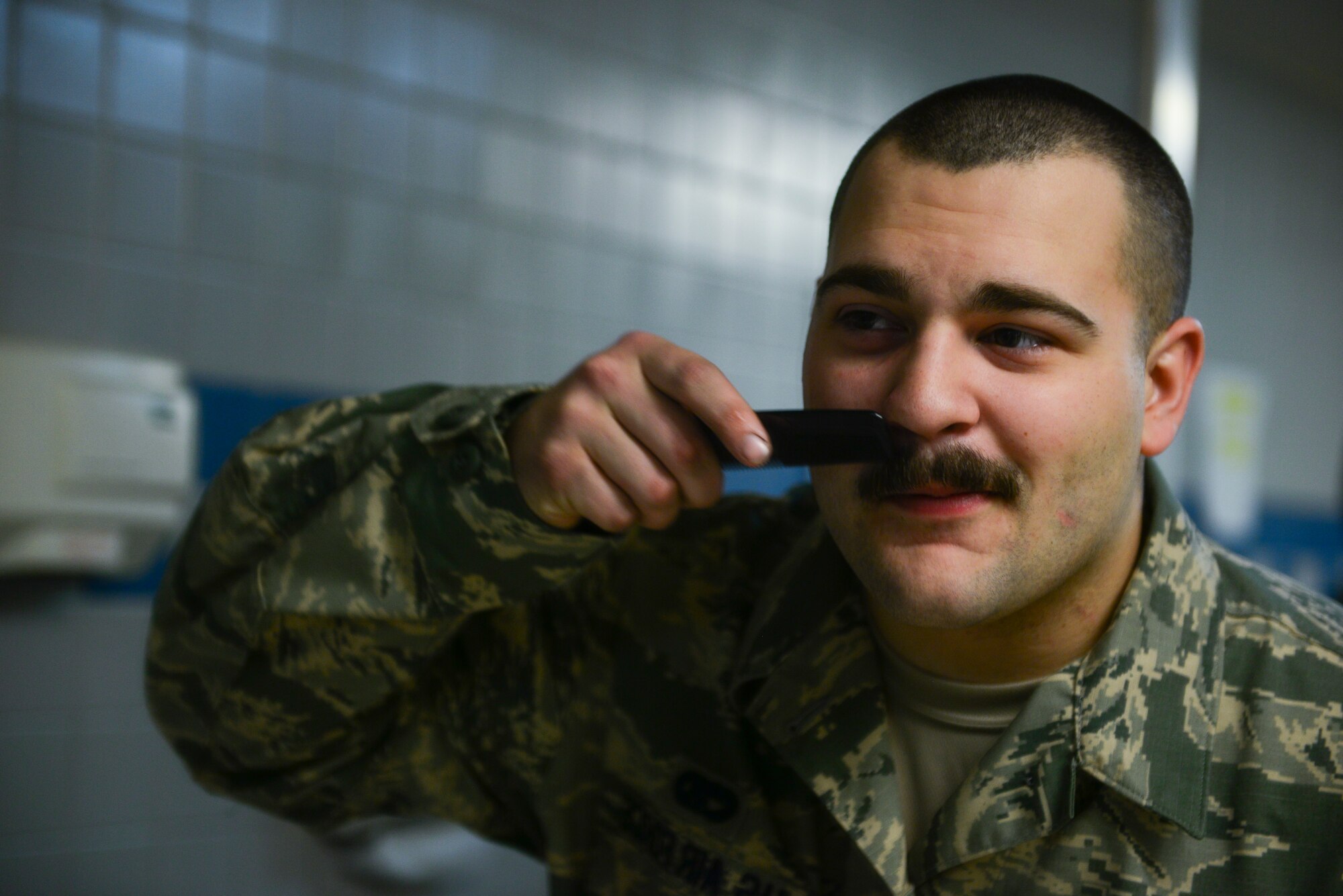 Senior Airman Jordan Hoefs, 51st Logistics Readiness Squadron vehicle maintenance journeyman, combs his mustache March 27, 2014, at Osan Air Base, Republic of Korea. Hoefs nicknamed his mustache Rupert. (U.S. Air Force photo by Senior Airman David Owsianka)
