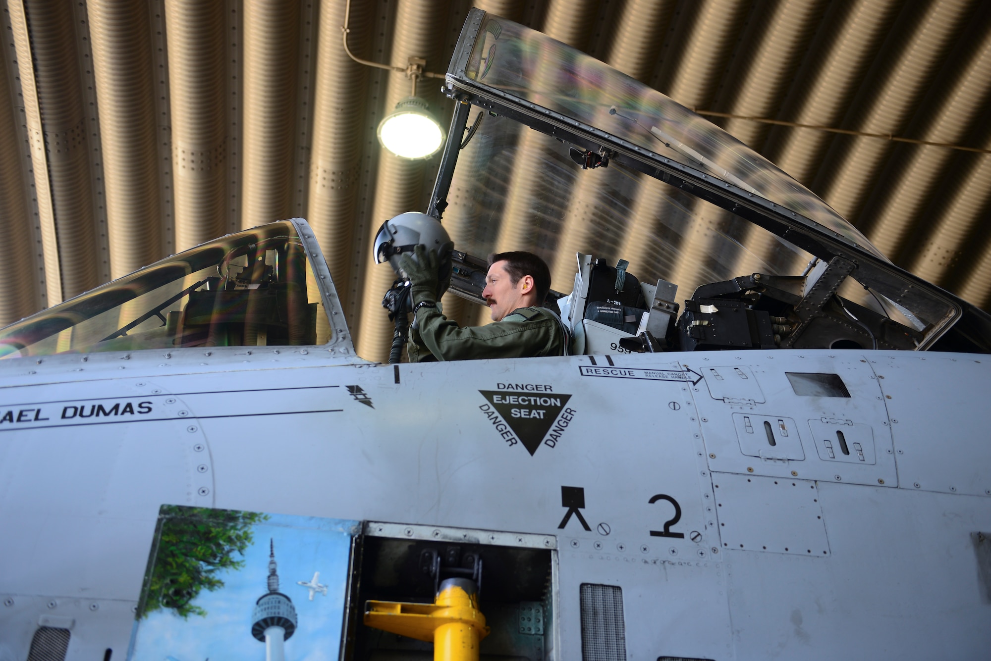 Capt. Aaron Knight, 25th Fighter Squadron pilot, puts on his helmet prior to completing a sortie Airman March 27, 2014, at Osan Air Base, Republic of Korea. Knight nicknamed his mustache the thunder-stache. (U.S. Air Force photo by Senior Airman David Owsianka)