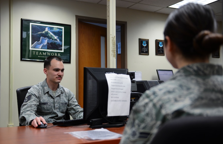 Staff Sgt. Gregory Corbitt, 51st Force Support Squadron customer support supervisor, makes a new ID card for an Airman March 26, 2014, at Osan Air Base, Republic of Korea. Corbitt nicknamed his mustache the identifier. (U.S. Air Force photo by Senior Airman David Owsianka)