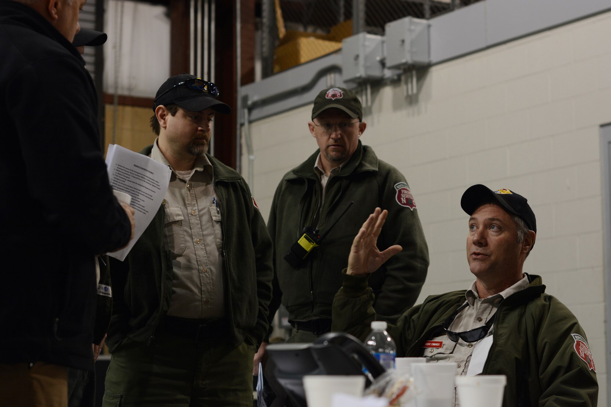 John Howard (right), North Carolina Forest Service incident commander, talks to members of the plans and operations section about asset utilization during the 2015 Vigilant Guard Exercise. This exercise, held at the 145th Civil Engineer Squadron Regional Training Site, New London, N.C., March 6-8, 2015, is designed to measure the effectiveness of National Guard forces supporting civilian activities following a hurricane. Howard is working in a team of three incident commanders, U.S. Air Force Lt. Col. Gregory Goforth, 145th Mission Support Group deputy commander representing the North Carolina Air National Guard, and Scot Brooks from the state Division of Emergency Management. (U.S. Air National Guard photo by Staff Sgt. Julianne M. Showalter, 145th Public Affairs/Released)