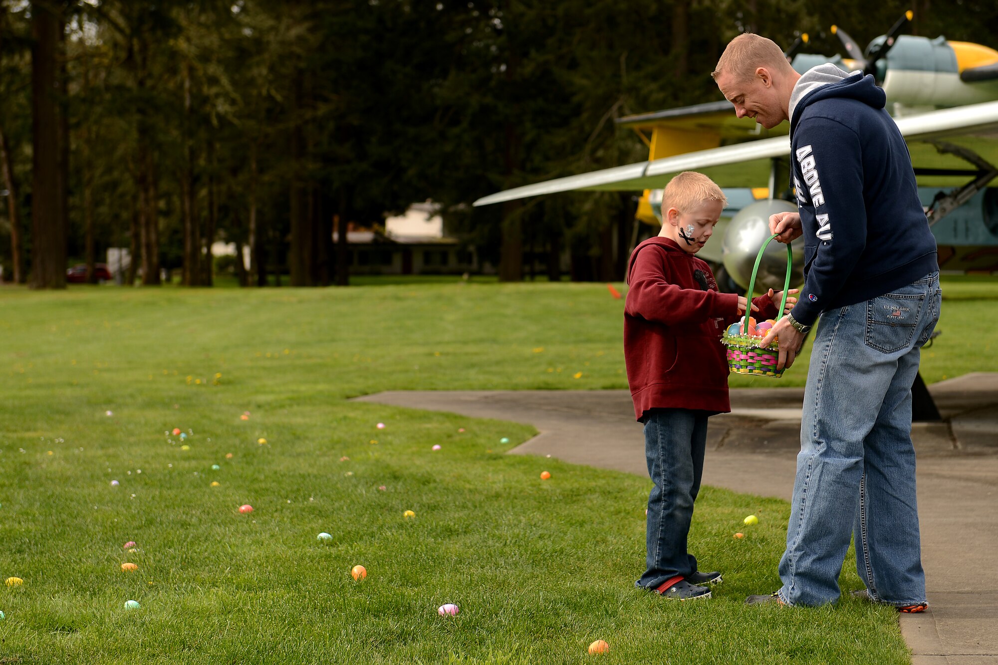 Capt. Eric Lane, 7th Airlift Squadron readiness flight commander, hunts Easter eggs with his son at Joint Base Lewis-McChord March 28,  2015. The Easter egg hunt was part of an annual event hosted by the McChord 5/6 Club. (U.S. Air Force photo/ Staff Sgt. Tim Chacon)