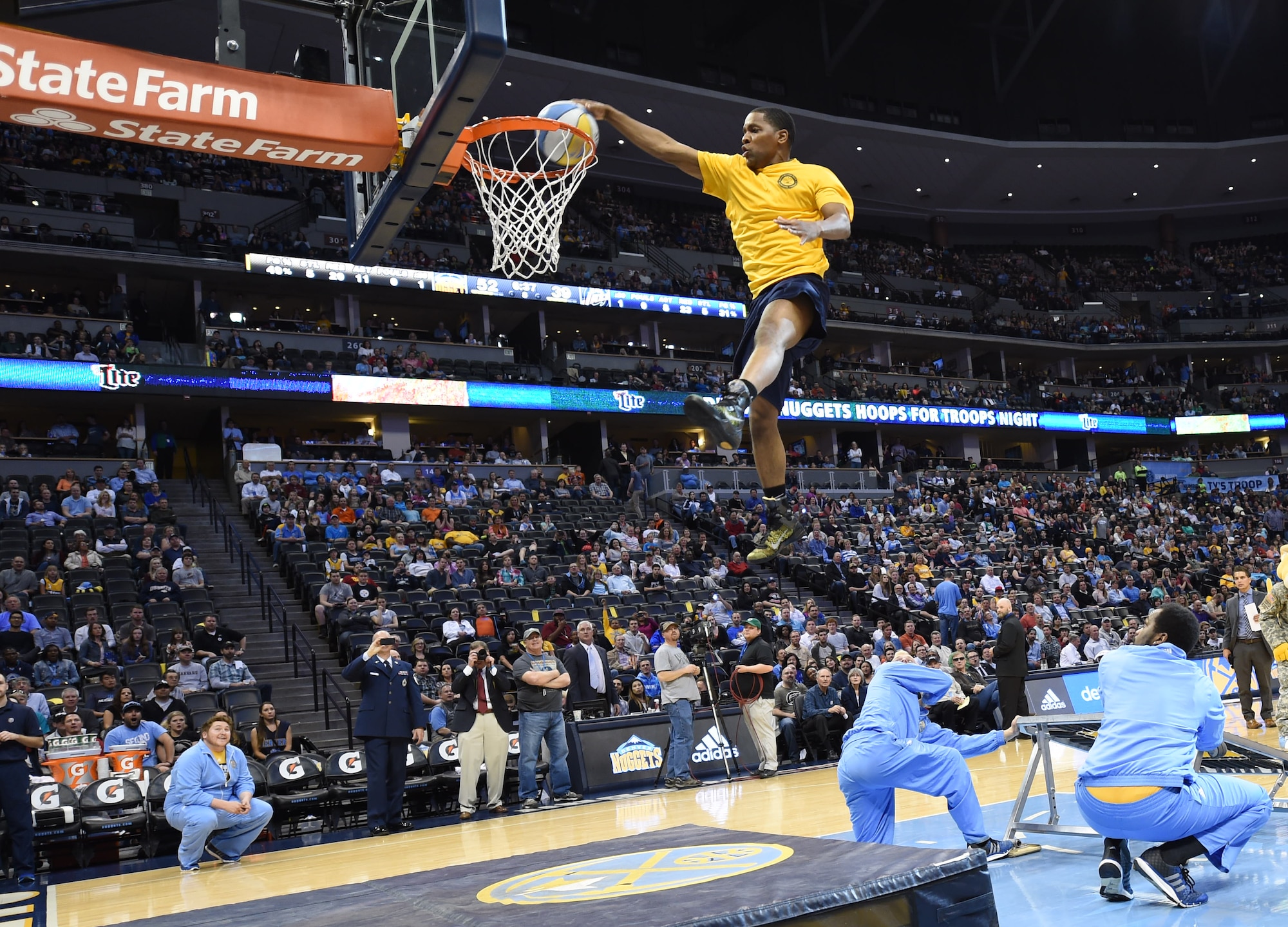 A U.S. Navy member dunks a basketball during the Hoops for Troops Night with the Denver Nuggets March 27, 2015, at the Pepsi Center in Denver. Hoops for Troops Night is held to honor military men and women with discounted ticket pricing, a halftime dunk contest and recognition of past, present and future military personnel from all branches. (U.S. Air Force photo by Airman 1st Class Samantha Saulsbury/Released)