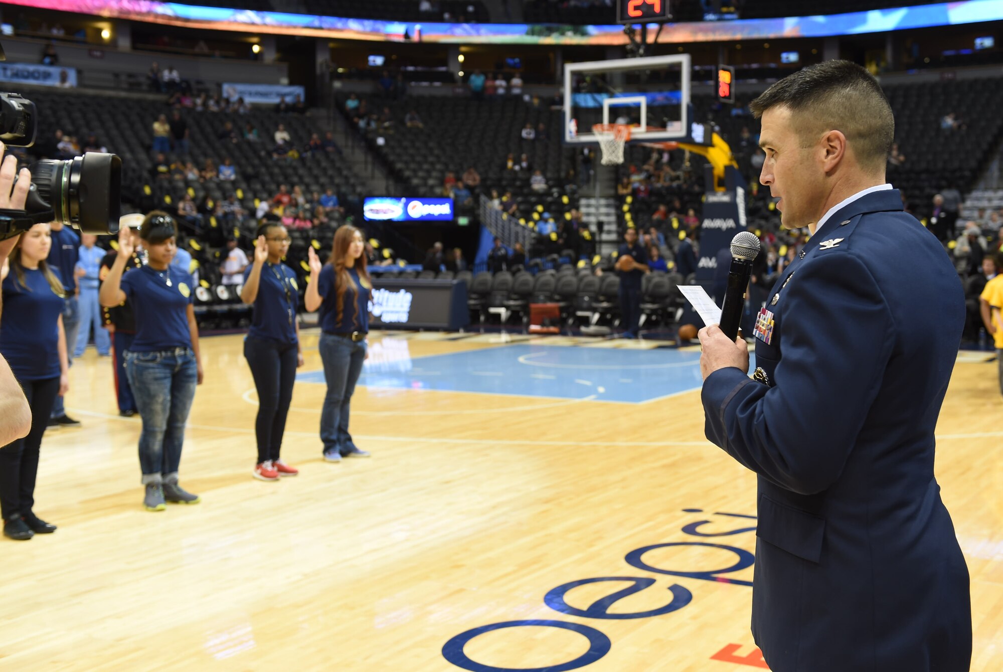 Col. John Wagner, 460th Space Wing commander, gives the oath of enlistment to recruits at the Hoops For Troops Night with the Denver Nuggets March 27, 2015, at the Pepsi Center in Denver. Hoops for Troops Night is held to honor military men and women with discounted ticket pricing, a halftime dunk contest and recognition of past, present and future military personnel from all branches. (U.S. Air Force photo by Airman 1st Class Samantha Saulsbury/Released)