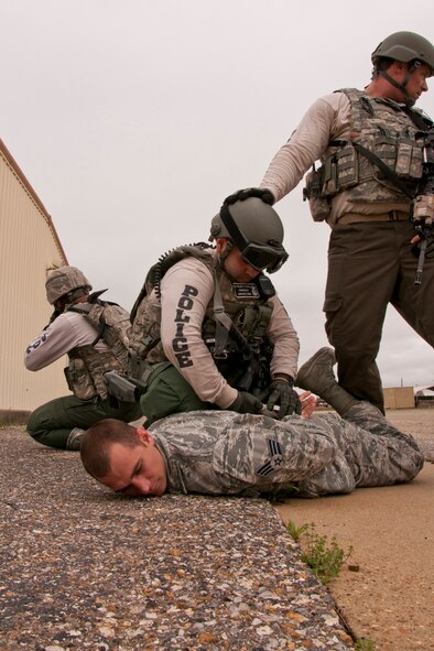 U.S. Air Force Tech. Sgt. Andrew Smoltz provides a security watch for Staff Sgt. Aldo Felici as he secures the final portrayed gunman during an Active Shooter Exercise at Barksdale Air Force Base, La., March 20, 2015. Both Airmen are members of the 2nd Security Forces Squadron’s Emergency Services Team that was involved in apprehending two suspects and a hostage negotiation during an exercise intended to test the ability of the Airmen in responding to an active shooter event. (U.S. Air Force photo by Master Sgt. Jeff Walston)