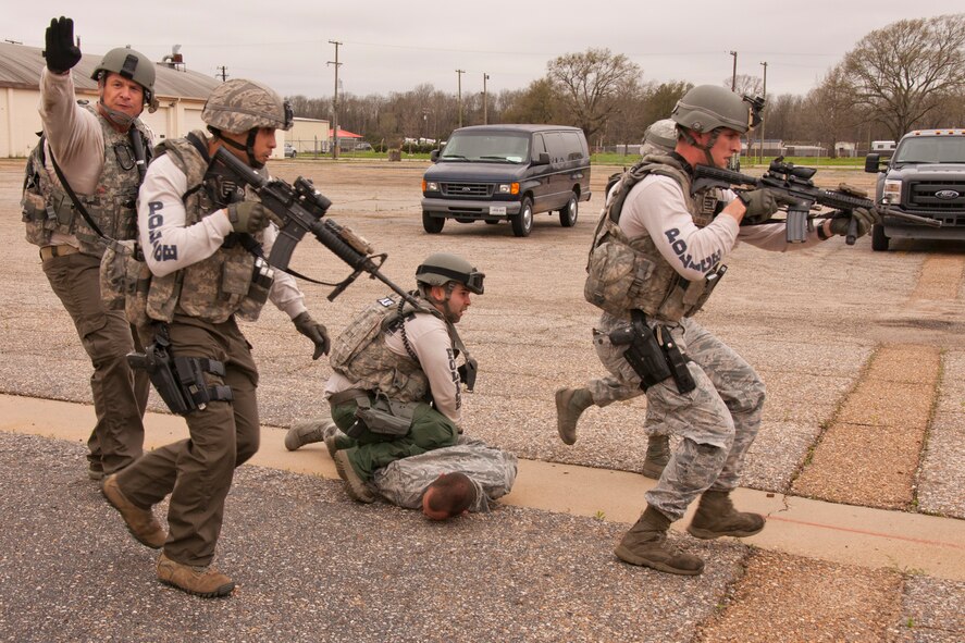 Members of the 2nd Security Forces Squadron, Emergency Services Team secure the final simulated suspect when he surrenders after negotiations during an Active Shooter Exercise at Barksdale Air Force Base, La., March 20, 2015. The exercise involved apprehending two suspects and a hostage negotiation and was intended to test the ability of the Airmen in responding to an active shooter event. (U.S. Air Force photo by Master Sgt. Jeff Walston)