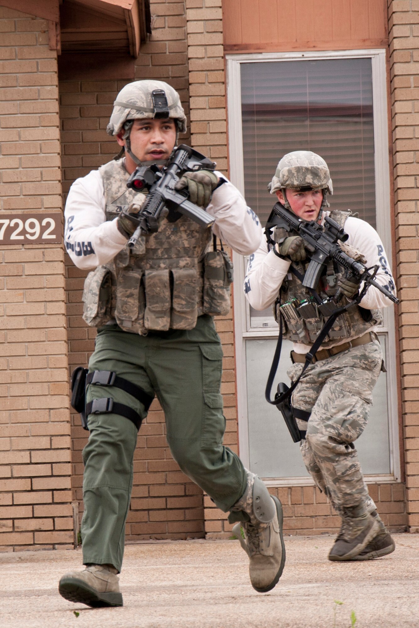U.S. Air Force Staff Sgts. Jezrell Zimmerman and Tommy Lester, who are members of the 2nd Security Forces Squadron, Emergency Services Team move across the 307th RED HORSE compound as they search for a suspected gunman during an Active Shooter Exercise at Barksdale Air Force Base, La., March 20, 2015. A secondary mission of the exercise was to negotiate the release of a hostage and the surrender of the portray gunmen holding him. (U.S. Air Force photo by Master Sgt. Jeff Walston)