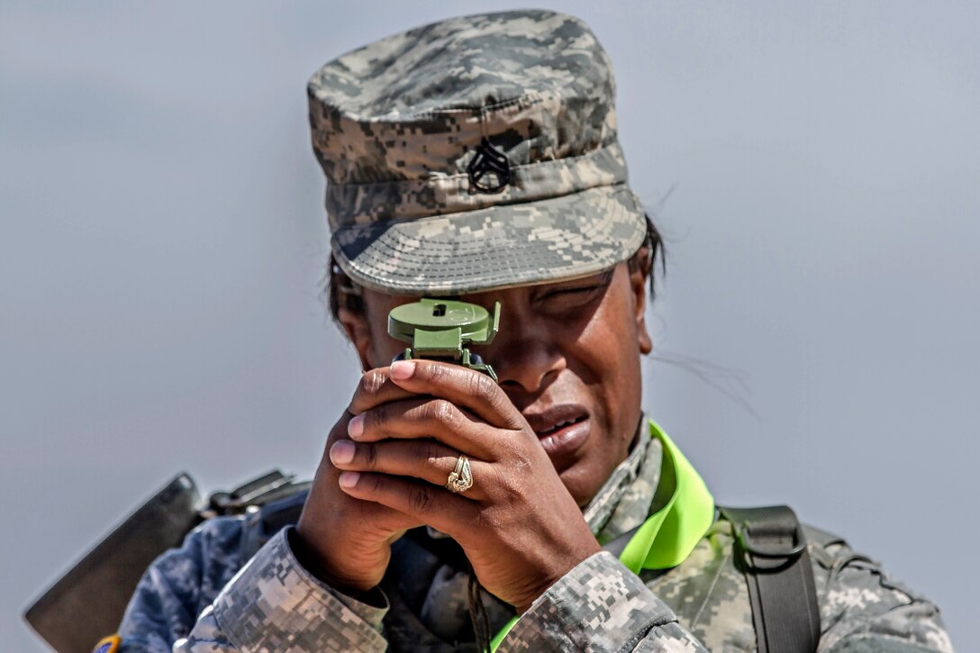 Army Staff Sgt. Mercedes Green uses a lensatic compass to shoot an azimuth at the day land navigation course during the 2015 Best Warrior and Drill Sergeant of the Year Competition on Fort Huachuca, AZ., March 26, 2015. Green is assigned to the 95th Training Division.