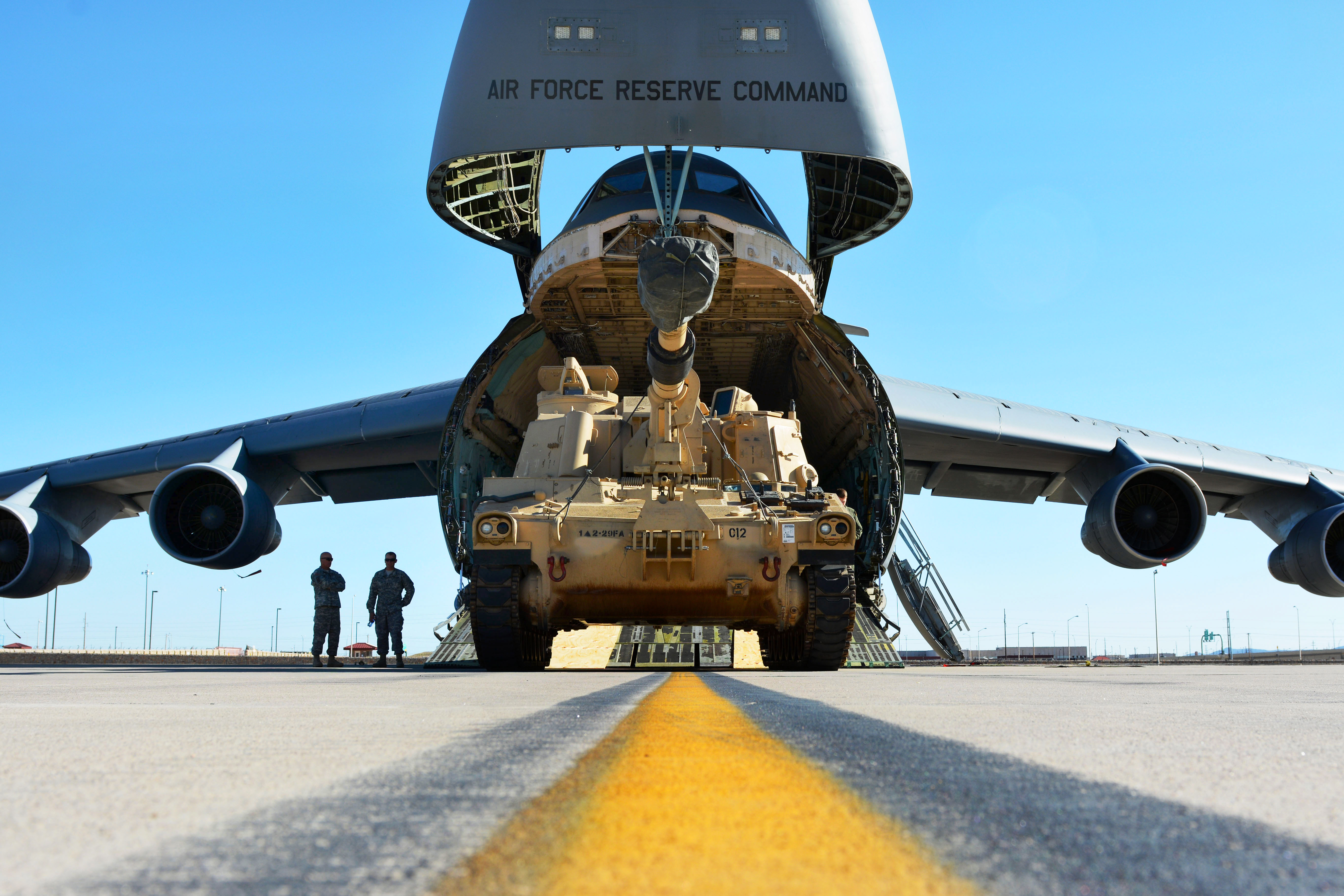 Soldiers and airmen conduct a air movement with two M109A6
