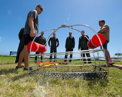 Tech. Sgt. Jeffrey Ray, a Survival Evade Resist and Escape specialist for the 15th Operational Support Squadron explains the different types of recovery devices used for water rescues to Airmen from the 535th Airlift Squadron 65th Airlift Squadron, and the 96th Air Refueling Squadron during water survival training on Joint Base Pearl Harbor-Hickam, Hawaii, March 23, 2015. The water survival training is a triennial requirement for all aircrew to refresh their SERE water survival skills. (U.S. Air Force photo by Tech. Sgt. Aaron Oelrich/Released)  