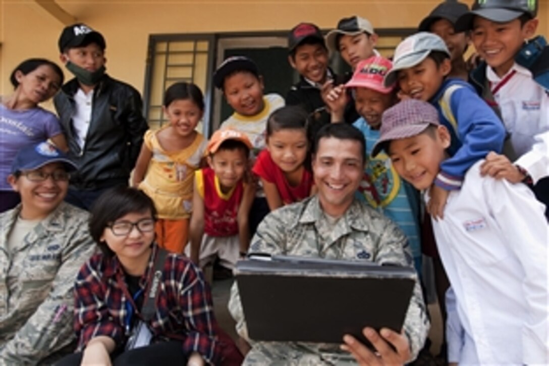 U.S. Air Force Master Sgt. Erick Lizarraga entertains local youths at South Tinh Phong primary school during an engineering project in the Quang Ngai province, Vietnam, March 26, 2015. Efforts undertaken during Operation Pacific Angel 2015 help multilateral militaries in the Pacific improve and build relationships across a wide spectrum of civic operations, bolstering each nation's capacity to respond and support future humanitarian assistance and disaster relief operations. 