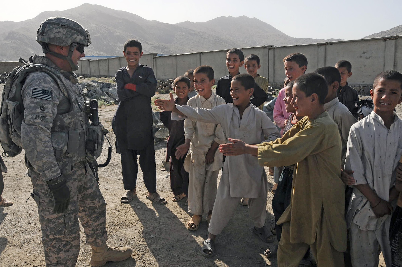 Sgt. 1st Class Kristopher Alvey, civil military operations (CMO) noncommissioned officer of the 1st Battalion, 178th Field Artillery, South Carolina Army National Guard, plays with local Afghan children June 27, 2010, outside of Walayatee school in Afghanistan. Alvey and other members of the CMO are building bonds with Afghan citizens while managing the construction processes of schools and other building infrastructure around the Kabul area.