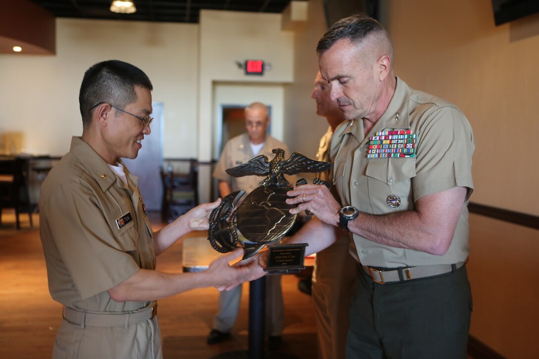 Lt. Cmdr. Vinh T. Ton, dentist for 1st Dental Battalion, receives the LTJG Weedon E. Osborne award from Maj. Gen. Vincent A. Coglianese, commanding general for 1st Marine Logistics Group at Pacific Views Event Center aboard Camp Pendleton, Calif, March 27, 2015. The award is earned by a dental officer who makes significant contributions to operational readiness. It is presented annually by the Marine Corps Association. The award is named in honor of Lt. j.g. Weedon E. Osborne, Dental Corps, U.S. Navy, who was killed in action during the battle of Belleau Wood in France in 1918. “When I reflect upon the pool of other extraordinarily dedicated and talented practitioners nominated for this award, words cannot express the depth of my humility for having been chosen for this honor,” said Ton. “I would like to share the honor of this award with all those who were also nominated, truly any of you could have been selected for this award.”