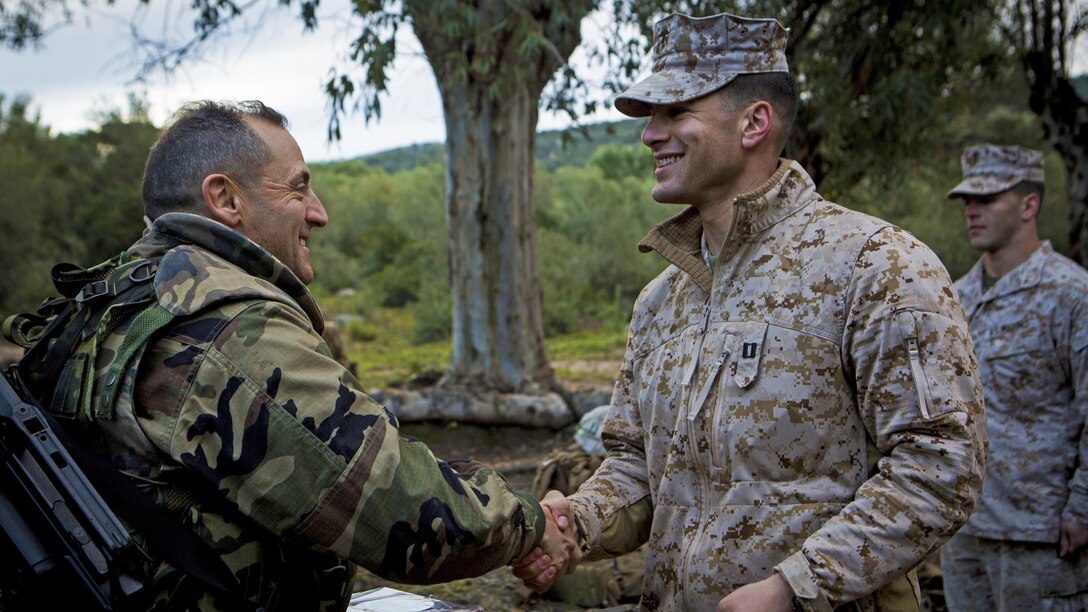 Spanish Marine Corps Lt. Col. Evaristo Gutierrez del Castillo, left, commanding officer, 2nd Infantry Battalion, shakes hands with U.S. Marine Corps Capt. Daniel Lakhani, the ground combat element company commander with Special-Purpose Marine Air-Ground Task Force Crisis Response-Africa, after a variety of live-fire training exercises in Sierra del Retin, Spain, March 26, 2015. Lakhani presented Castillo with the plaque for opening the Spanish Marines’ training ranges to conduct several live-fire training exercises using a variety of weapon systems to include the AT-4 anti-armor weapon, M240B machine gun, and M67 fragmentation grenade. 