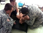 Sgt. Russell Moss (right), a medic for Company A, 309th Military Intelligence Battalion of the U.S. Army, instructs a student in combat lifesaver training at Volk Field Combat Readiness Training Center, Wis.