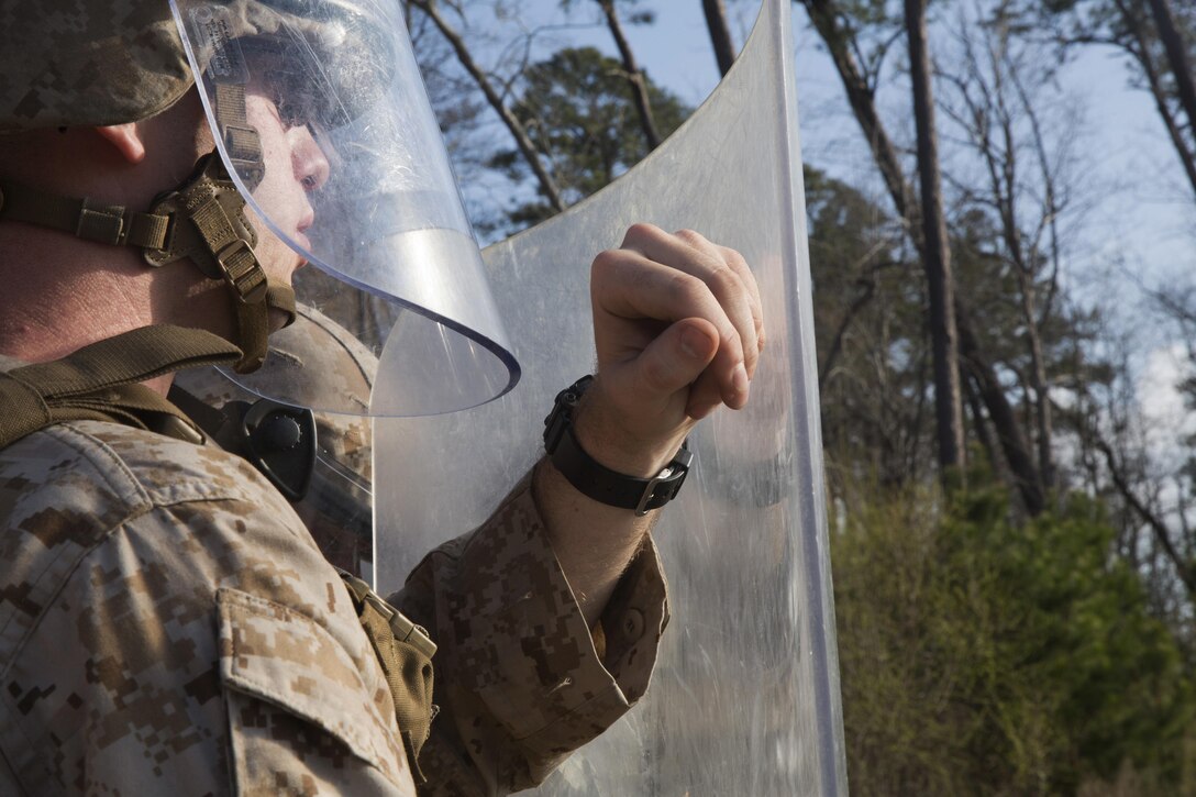 A Marine with 2nd Battalion, 6th Marine Regiment, waits for the command to rush forward during a non-lethal weapons training exercise aboard Camp Lejeune, N.C., March 25, 2015. The Marines participated in a two-week NLW course that teaches various riot-control methods.