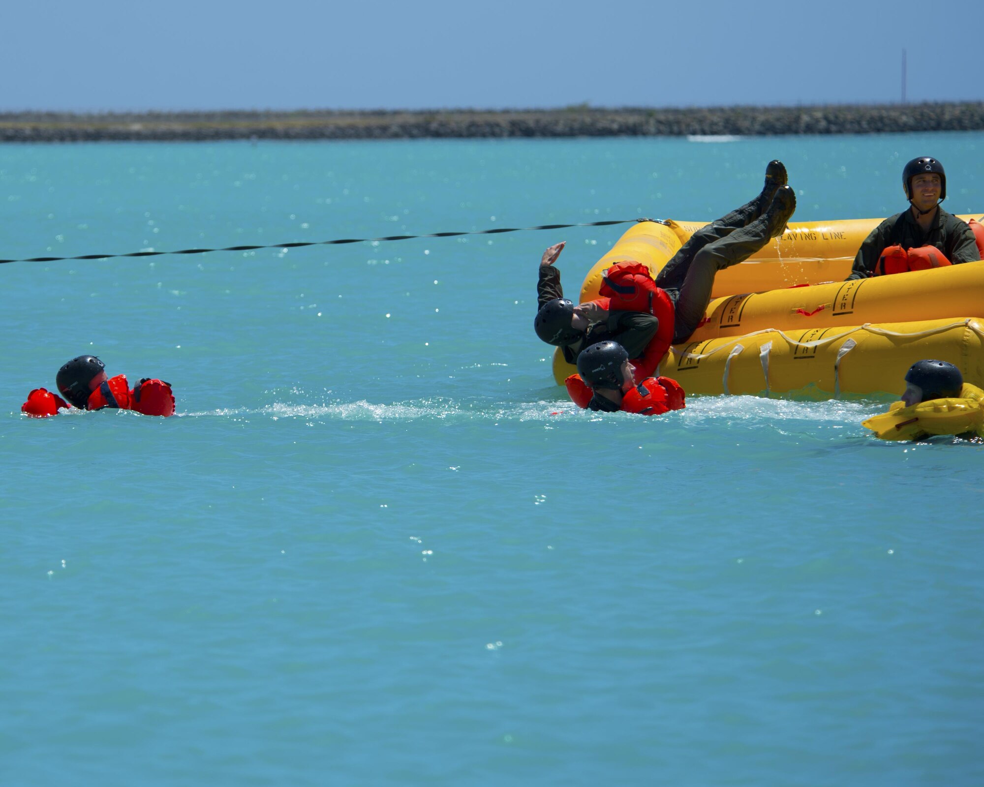 Airmen jump into Hickam Harbor to simulate exiting an aircraft that has landed in the ocean during water survival training March 23, 2015, at Joint Base Pearl Harbor-Hickam, Hawaii. Water survival training is completed on triennial basis for all aircrew assigned to the 15th Wing. The Airmen participating in the training were from the 535th Airlift Squadron, 65th Airlift Squadron and the 96th Air Refueling Squadron. (U.S. Air Force photo/Tech. Sgt. Aaron Oelrich)