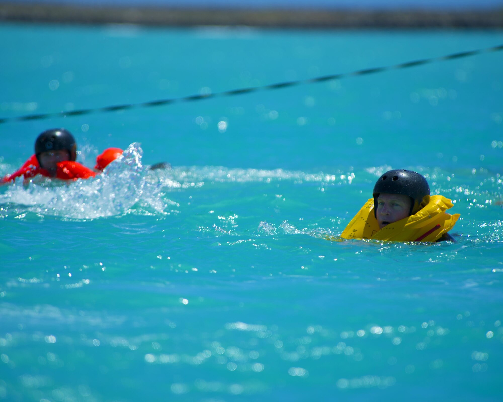 Lt. Col. David Hammer swims toward the dock at Hickam Harbor after egressing from a 46-person life raft during water survival training March 23, 2015, at Joint Base Pearl Harbor-Hickam, Hawaii. The water survival training is a triennial requirement for all aircrew. Hammer is the director of operations for the 65th Airlift Squadron. (U.S. Air Force photo/Tech. Sgt. Aaron Oelrich)