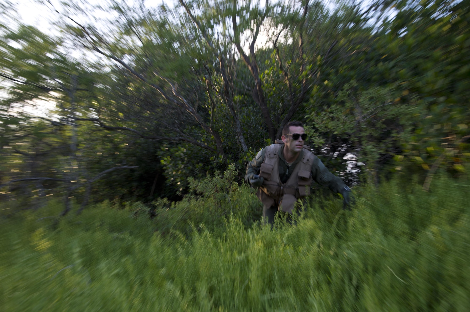 Senior Airman Kenneth Stricker runs from cover during combat survival training March 26, 2015, at Joint Base Pearl Harbor-Hickam, Hawaii. This training simulates the aircrew going down in a hostile environment. The aircrew uses teamwork to conceal their location, evade opposition forces and practice proper recovery procedures. Stricker is a boom operator for the 96th Air Refueling Squadron. (U.S. Air Force photo/Tech. Sgt. Aaron Oelrich)