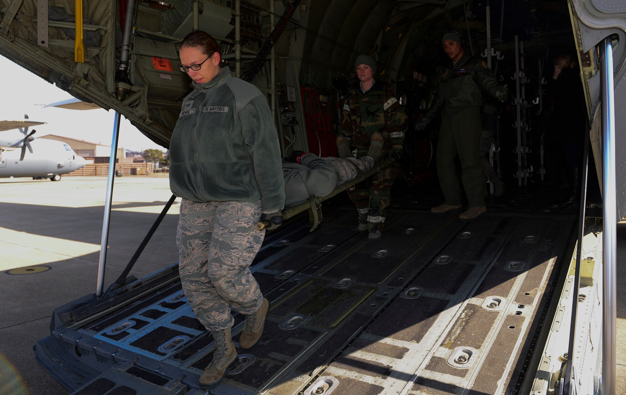 Airmen remove a person from the aircraft after completing a medical evacuation airlift training scenario March 4, 2015, at Osan Air Base, Republic of Korea. Medical evacuations are a timely and efficient movement and en route care provided by medical personnel to evacuate wounded personnel. (U.S. Air Force photo by Senior Airman David Owsianka)