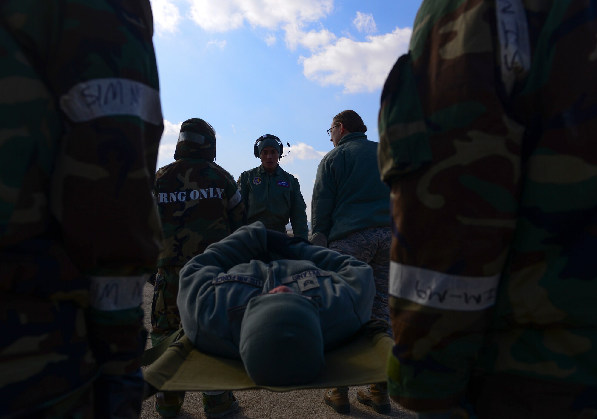 Capt. Weber Munsayac, 18th Air Medical Evacuation Squadron flight nurse, Kadena Air Base, Japan, instructs Airmen on how to effectively carry a litter with a person during a medical evacuation airlift training scenario March 4, 2015, at Osan Air Base, Republic of Korea. The Beverly Midnight 15-01 exercise is designed to test American forces in the ROK on their mission readiness in the event of an emergency or wartime environment. (U.S. Air Force photo by Senior Airman David Owsianka)