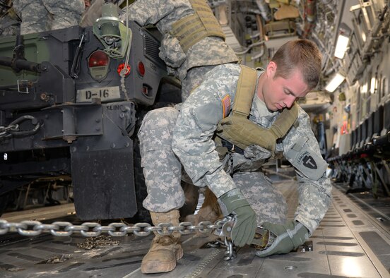 PERRIN AIRFIELD, Texas – U.S. Army Spc. Cody Dunlap, 1st Battalion (Airborne), 143rd Infantry Regiment infantryman, tightens the cargo hold chains on a U.S. Army Humvee, ensuring the vehicle is secured properly on a U.S. Air Force C-17 Globemaster III cargo aircraft, March 27, 2015. Airmen from Altus Air Force Base met with Soldiers from the 143rd for a joint-force exercise. (U.S. Air Force photo by Senior Airman J. Zuriel Lee/Released)