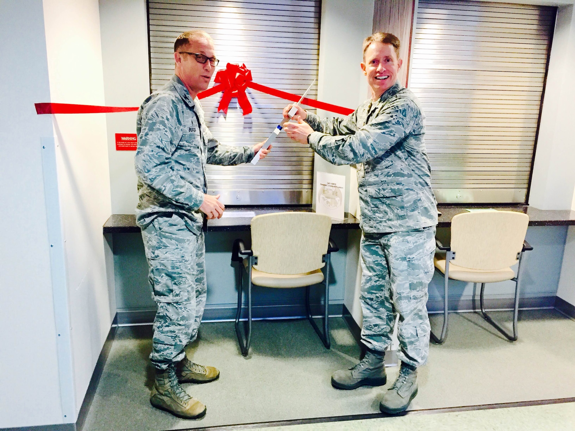 TRAVIS AIR FORCE BASE, Calif. -- Col. Matthew Burger, 349th Air Mobility Wing commander, and Col. Matthew Wonnacott, 60th Medical Group deputy commander, get ready to cut the ribbon to open the Reserve Component Liaison desk in David Grant Medical Center Mar. 23. It is located on the second floor, at the first window of the Patient Services Center. (Courtesy photo) (Courtesy photo/Released)