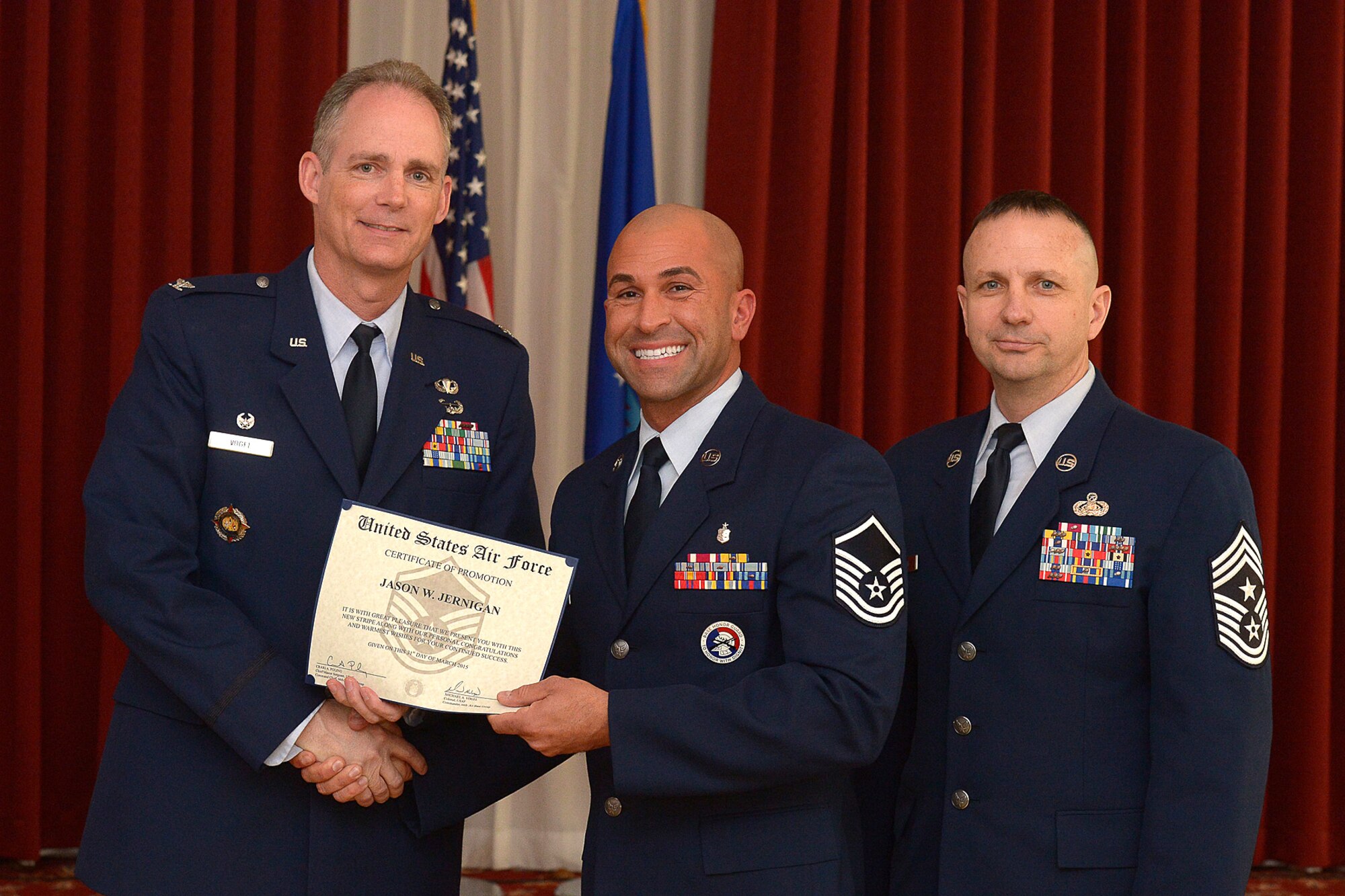 66th Air Base Group Commander Col. Michael A. Vogel and Hanscom Command Chief Master Sgt. Craig A. Poling congratulate Tech. Sgt. Jason Jernigan, Patriot Honor Guard NCO in charge, on his promotion to master sergeant during the enlisted monthly promotion ceremony, March 31. The monthly enlisted promotion ceremony, which is generally held the last duty day of the month, provides the Hanscom community an opportunity to recognize enlisted members that are selected for promotion. (U.S. Air Force photo by Jerry Saslav)