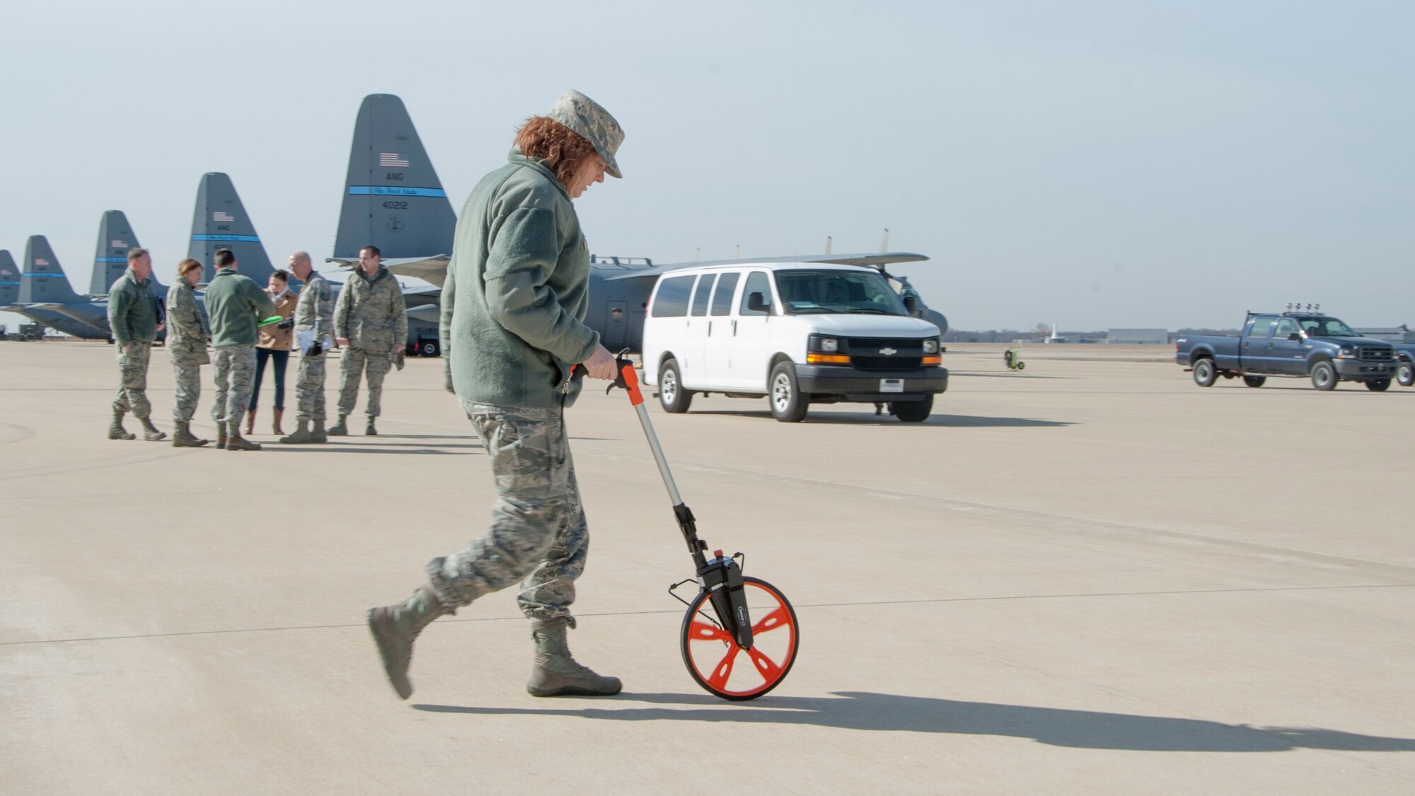Master Sgt. Joy Meek, a deployed broadcaster to Air Force Mortuary Affairs Operations, measures distances for setup during a dignified transfer divert exercise March 19, 2015, at New Castle Air National Guard Base, Del. The ANG base is AFMAO’s alternate location for dignified transfers should one need to be conducted due to inclement weather during runway construction at Dover Air Force Base, Del. (U.S. Air Force photo/Senior Airman Jared Duhon)