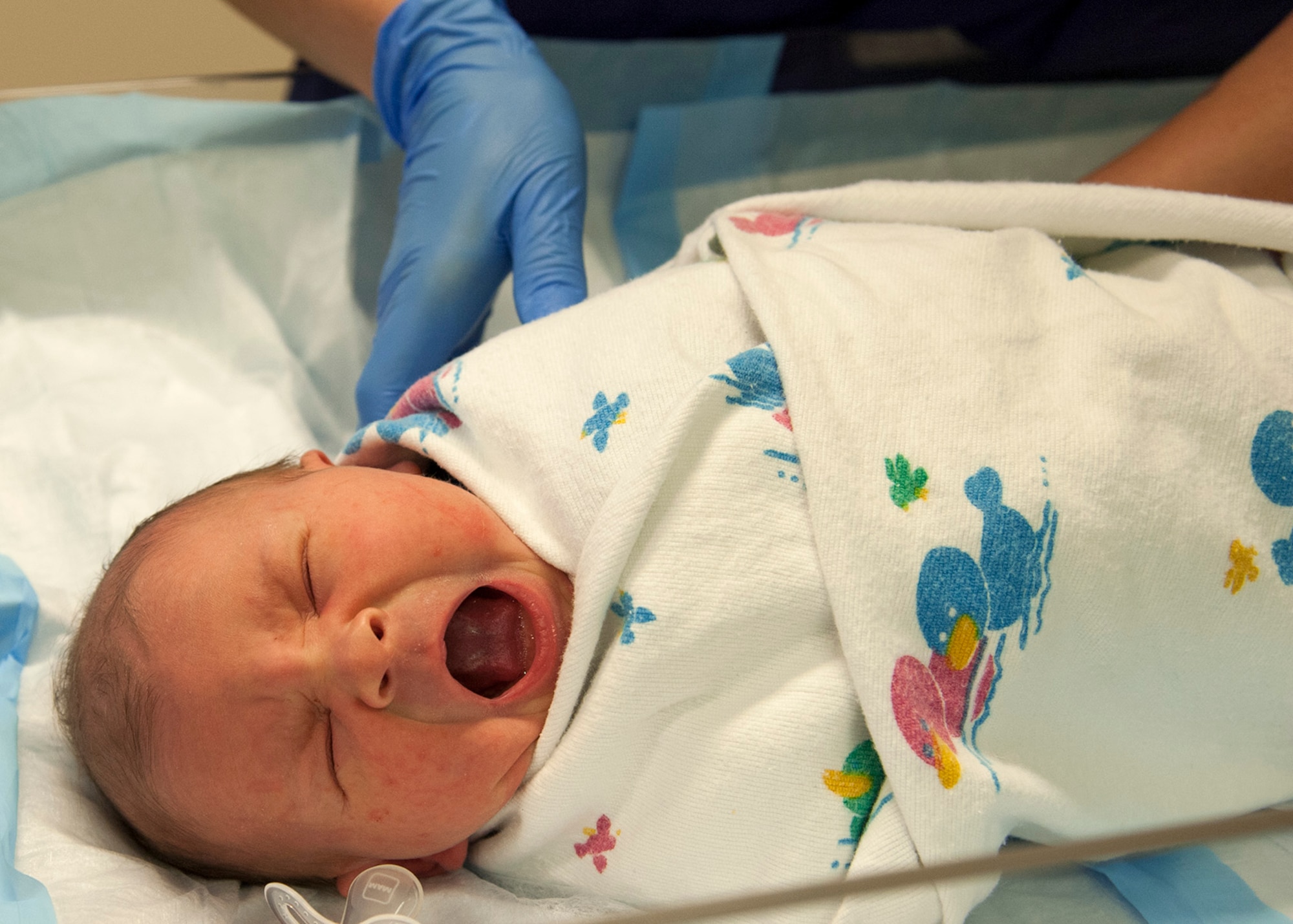 A labor and delivery technician from the 96th Medical Group’s Maternal Child (Labor and Delivery) Flight, swaddles a baby after a procedure, Feb. 24 at Eglin Hospital on Eglin Air Force Base, Fla. Technicians swaddle newborns to soothe them to sleep. The labor and delivery unit, part of the 96th Inpatient Squadron, provides care for all of Eglin’s newborn inpatients.  They delivered 764 babies in 2014. (U.S. Air Force photo/Ilka Cole)