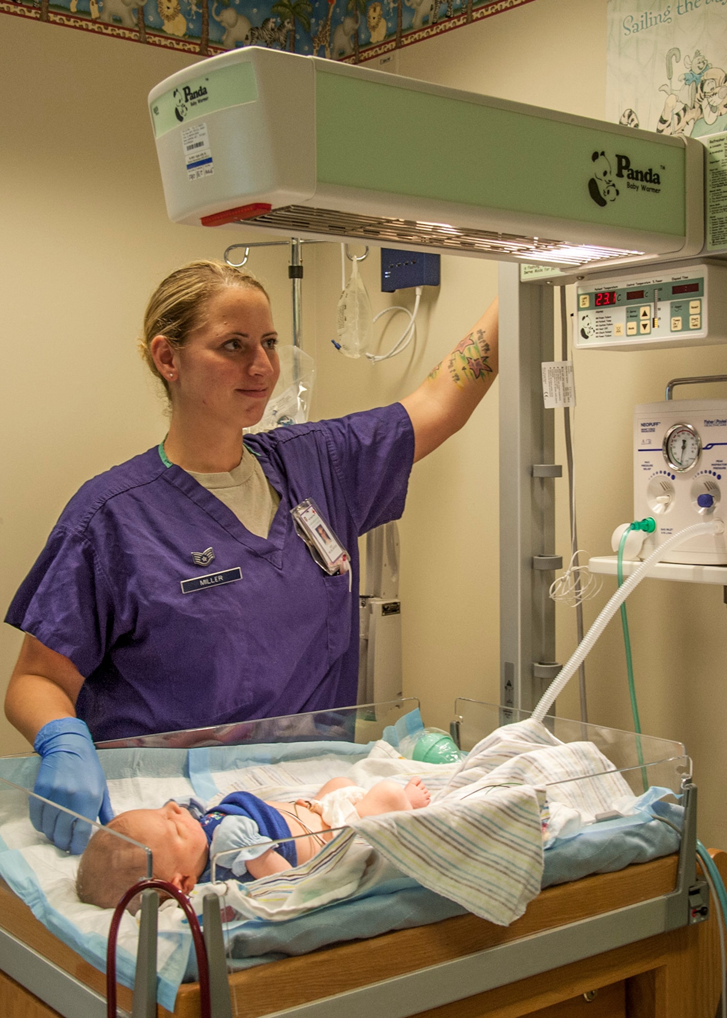 Staff Sgt. Krystle Miller, of the 96th Inpatient Squadron’s Maternal Child (Labor & Delivery) Flight, keeps the baby warm under a radiant warmer, Feb. 24 at Eglin Hospital on Eglin Air Force Base, Fla. Technicians place newborns under the warmer in an effort to stabilize their temperature. The labor and delivery unit provides care for all of Eglin’s newborn inpatients.  They delivered 764 babies in 2014. (U.S. Air Force photo/Ilka Cole)