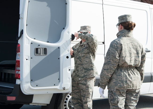Senior Master Sgt. Brian Denny, Air Force Mortuary Affairs Operations superintendent, demonstrates to Senior Airman Jamie Debbrecht, a 512th Memorial Affairs Squadron reservist deployed to AFMAO, the proper method to shut a transfer vehicle’s door March 19, 2015, at New Castle Air National Guard Base, Del. Airmen drove the van to New Castle, where it served as the transfer vehicle in the dignified transfer divert exercise, which tested AFMAO’s capability to perform a DT at an alternate site. (U.S. Air Force photo/Senior Airman Jared Duhon)