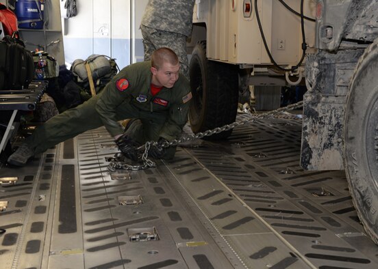 AUSTIN BERGSTROM INTERNATIONAL AIRPORT, Texas – U.S. Air Force Tech. Sgt. Chad Owens, 58th Airlift Squadron loadmaster, secures a U.S. Army Humvee in the cargo hold of a U.S. Air Force C-17 Globemaster III cargo aircraft on the flightline, March 27, 2015. Aircrew from Altus Air Force Base met with Soldiers from the 1st Battalion (Airborne), 143rd Infantry Regiment of the U.S. Army National Guard for a joint-force exercise. (U.S. Air Force photo by Senior Airman J. Zuriel Lee/Released)