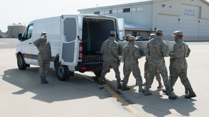 An Air Force Mortuary Affairs Operations carry team loads an empty transfer case during a dignified transfer divert exercise March 19, 2015 at New Castle Air National Guard Base, Del. Carry teams were able to familiarize themselves with executing their duties on a different flightline as part of the exercise. (Photo by Senior Airman Jared Duhon)